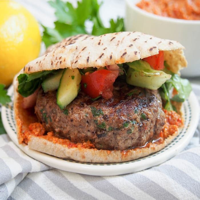 Juicy burger patty loaded with salad in a soft bun